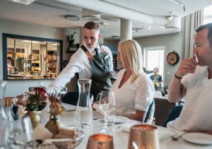Servitør sjenker vin til par på restaurant